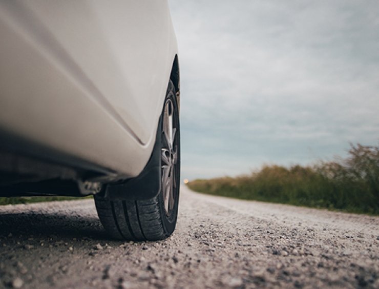  bílé auto jedoucí po štěrkové cestě